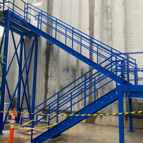 Customer needed additional office space above their dock doors. We filled the entire space, wall to wall, with mezzanine and In-Plant Office. We cut a hole in the existing concrete wall for door going out into the plant and 2nd door going out onto stairs outside for emergency egress. This was extremely custom as we had to get around 2 dock doors, 2 pedestrian doors, storm drain and a freight elevator. Everything fit like a glove and customer was very happy with the result.