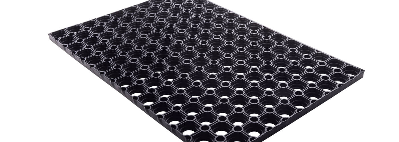 Black rubber entrance mat isolated on white background.